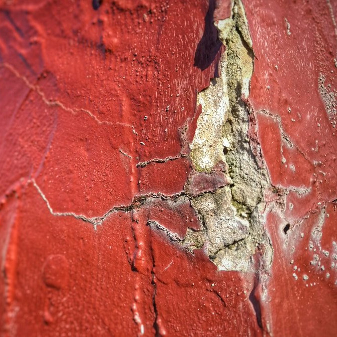 A bright red concrete wall with a chunk out of it.