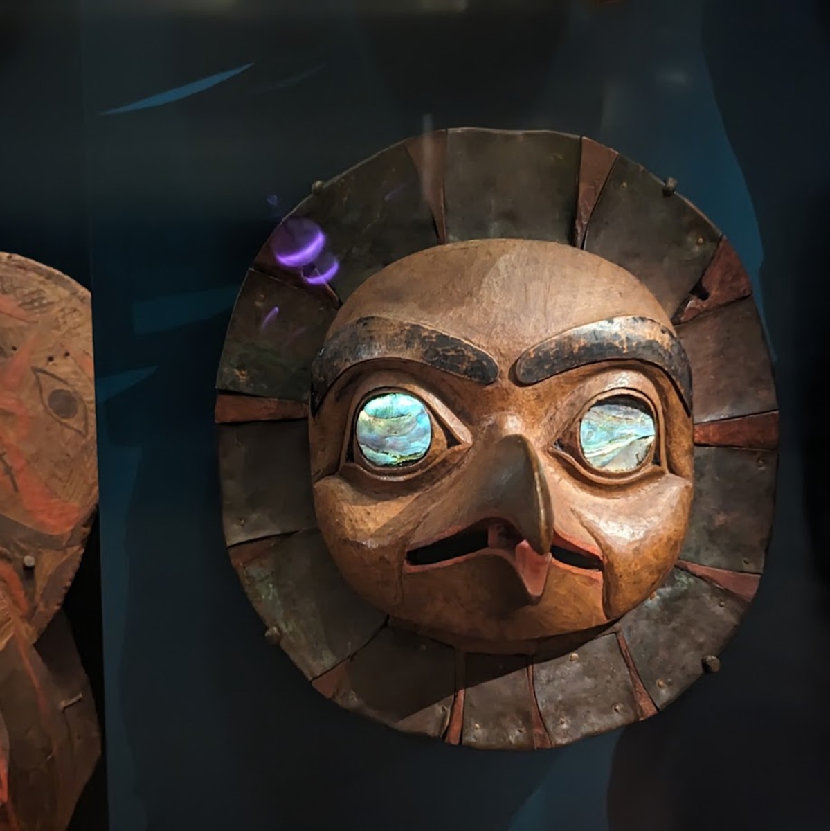 A mask with glowing stone eyes with a nose in the shape of a beak.