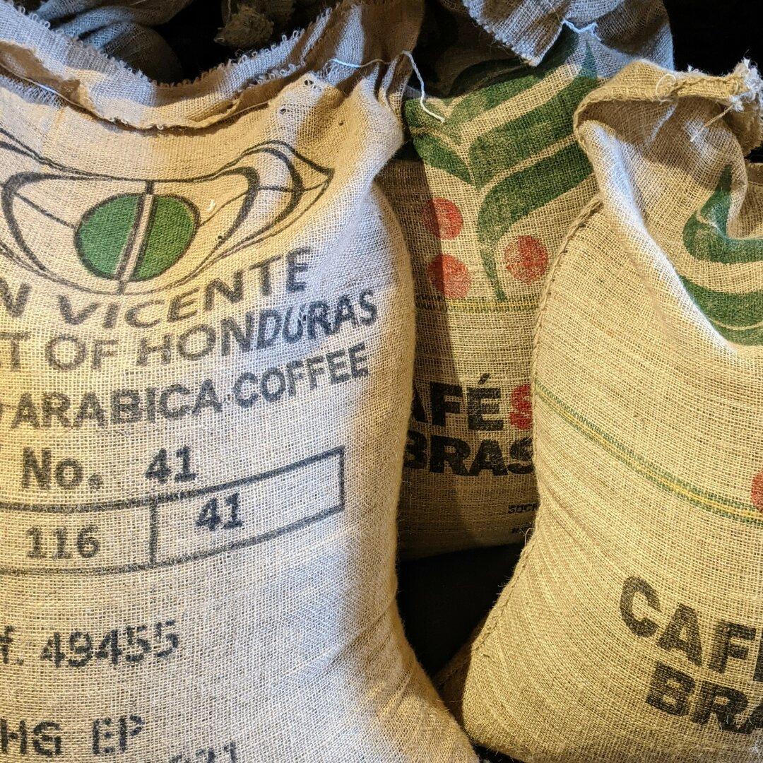 Several very large canvas bags labeled 'Arabica Coffee'