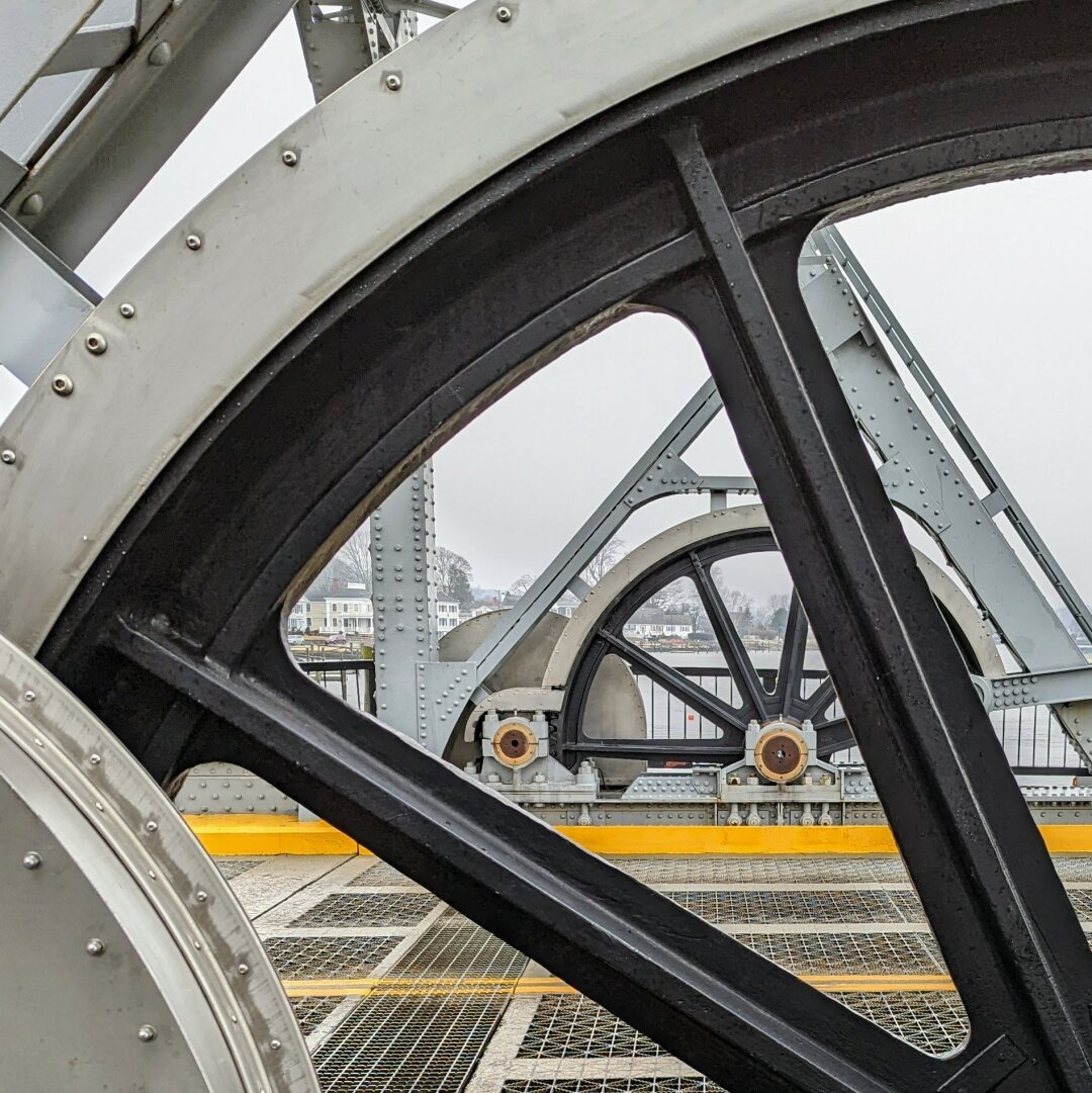 The large metal wheels on a small drawbridge