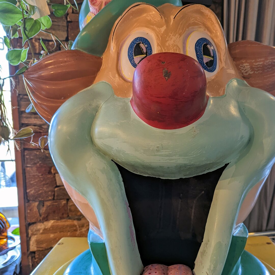 A clown statue, mouth wide open.