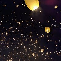 Looking straight up into the pitch black sky with several hundred glowing paper lanterns