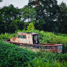 a very old boat sitting in the middle of a field